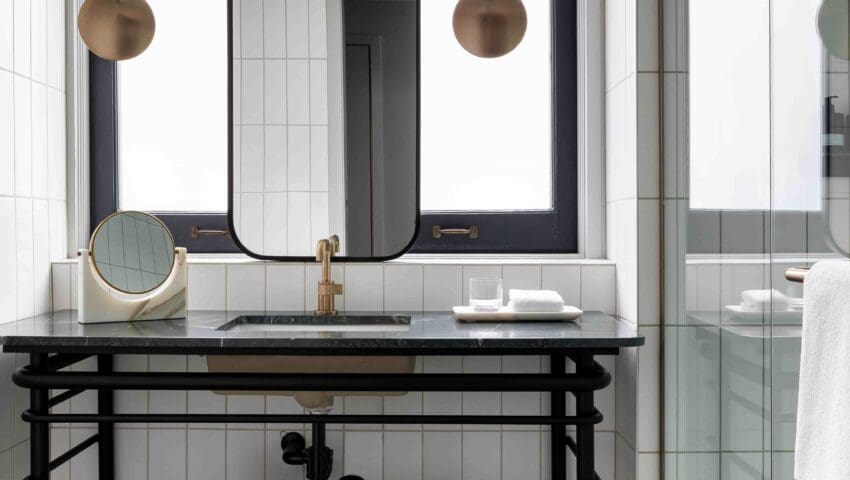 Bathroom with sink in a black frame and a mirror hanging just above the sink